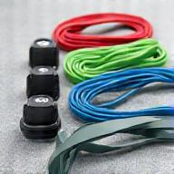 A set of colorful resistance bands neatly coiled, with a door anchor and instruction manual, against a clean athletic background.