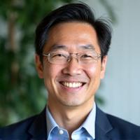 Smiling male wellness coach, Liam Chen, specializing in Sleep Optimization and Stress Management.